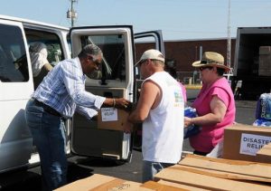 Individuals giving disaster relief box to another individual