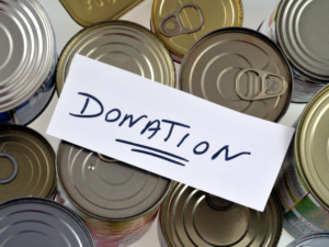 Several cans with a piece of paper on top that says, "Donation"