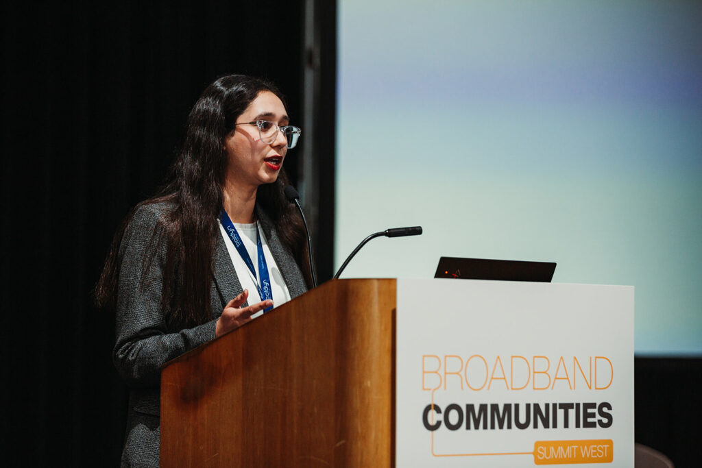 Sara Raza speaks at a podium at the Broadband Communities Summit West Conference